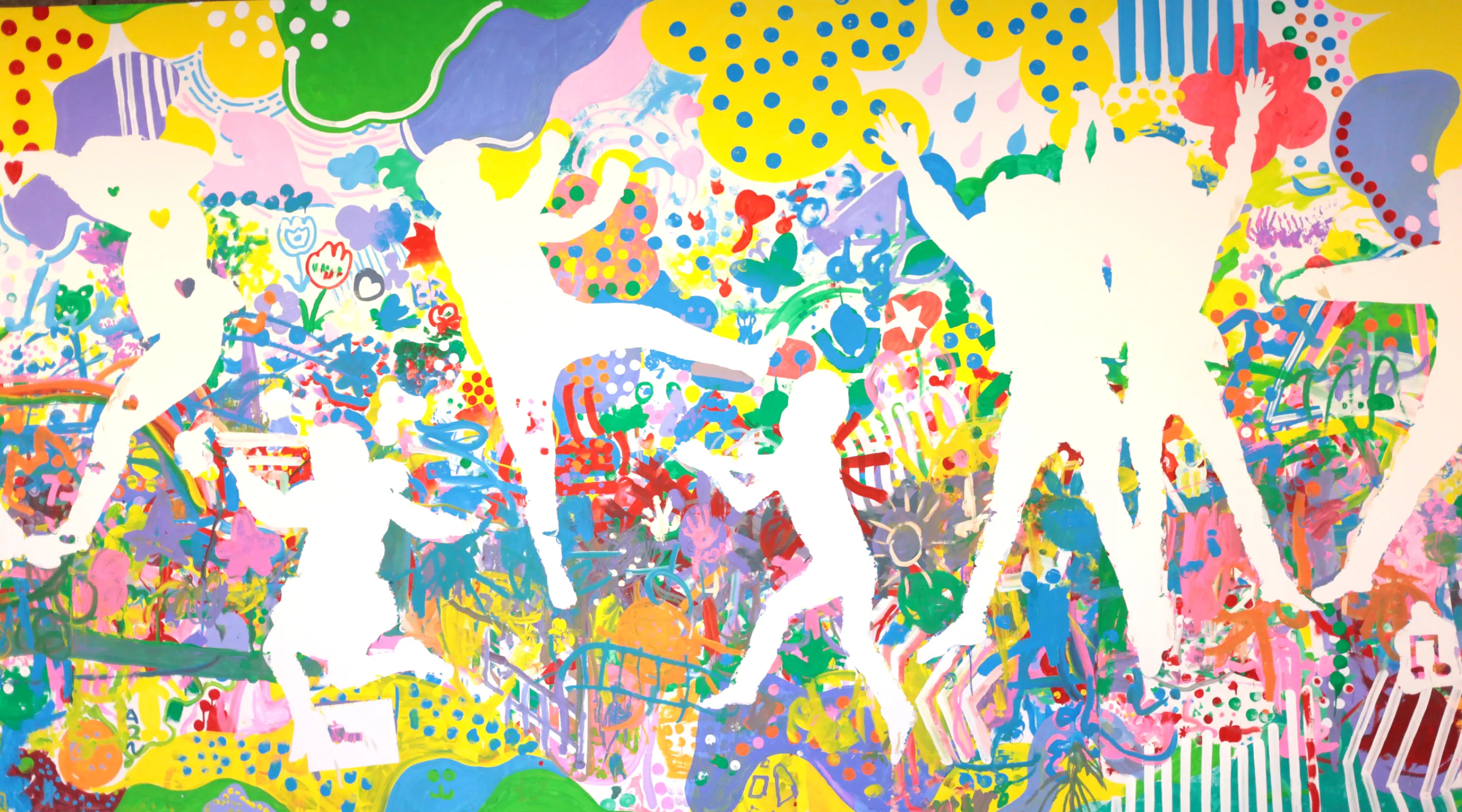 写真：カラフルな背景に子どもたちのシルエットが浮かび上がっている絵